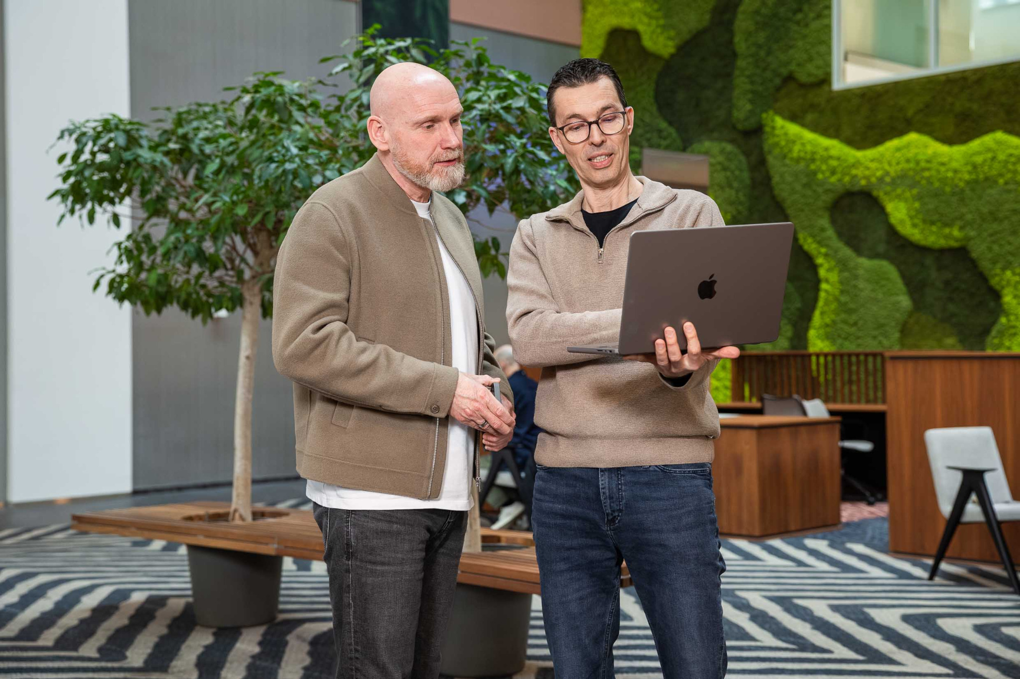 Two SECWATCH colleagues discuss information on a laptop.
